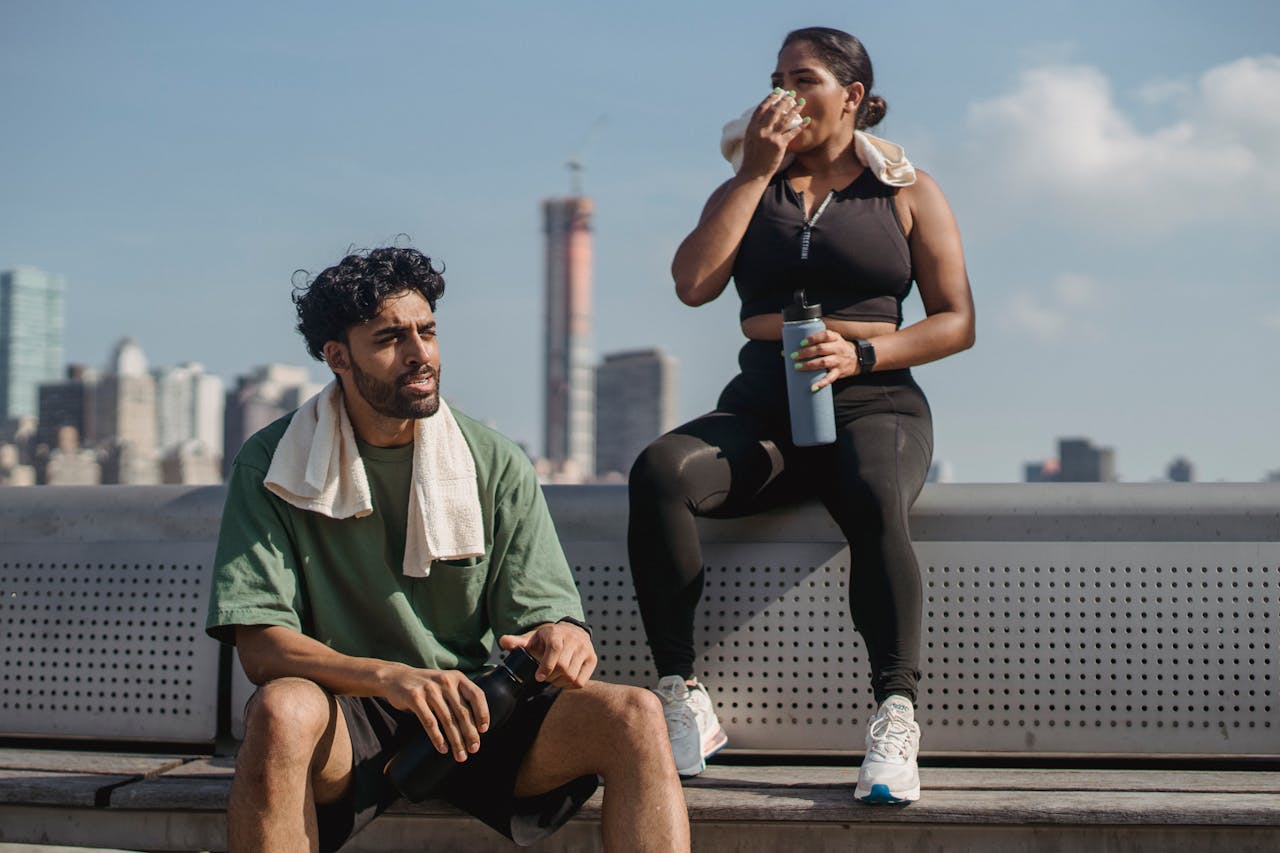 Two people resting after exercise in a city setting, promoting a healthy lifestyle.